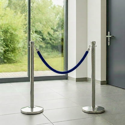 Two silver stanchions with a blue rope in front of a glass door.